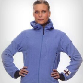 A woman in blue jacket standing with her hands on hips.