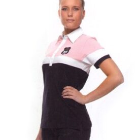 A woman in black and white shirt standing next to a wall.