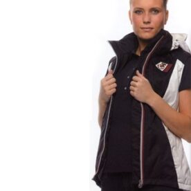 A woman in black and white jacket holding her arms.