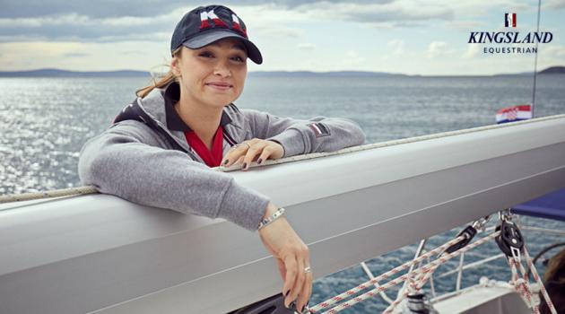 A woman leaning on the railing of a boat.
