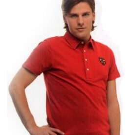 A man in red shirt standing with hands on hips.